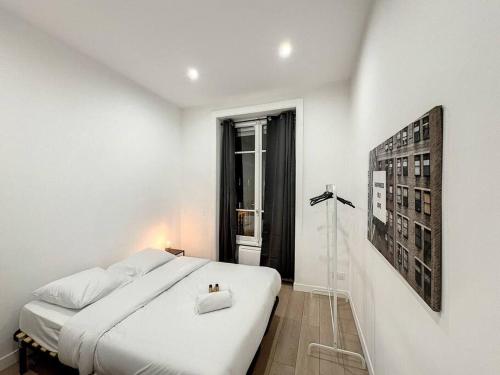 une chambre blanche avec un grand lit et une fenêtre dans l'établissement Cosy appart, Lyon Préfecture Servient 2, à Lyon