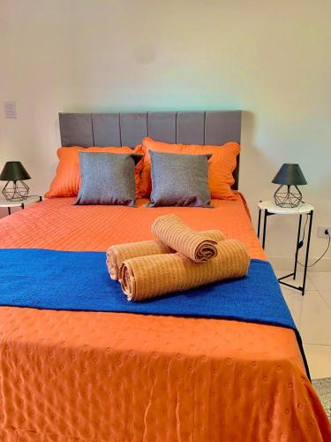 a large orange bed with two towels on it at Studio Vertentes in Sao Paulo