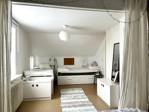 Cette chambre blanche comprend deux lits et une table. dans l'établissement House in Tärnaby, à Tärnaby