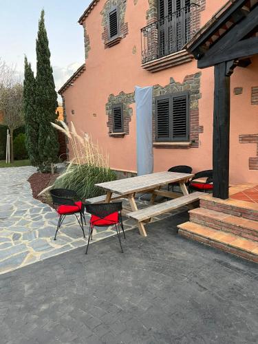 a picnic table and two chairs in front of a building at Villa Sol Luxury Costa Brava Golf in Peralada