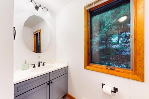 a bathroom with a sink and a mirror and a window at Alpine Bliss in Brownsville