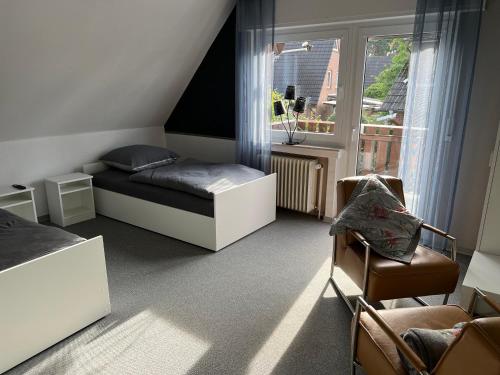 een slaapkamer met een bed, een stoel en een raam bij Pension Gauerbach Lingen in Lingen
