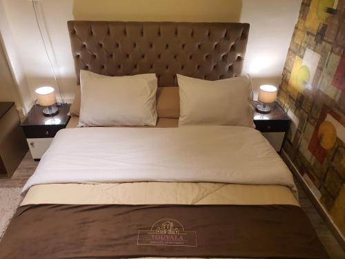 a bedroom with a large bed with two night stands at YOUVALA Serviced Apartment 2nd District in 6th Of October