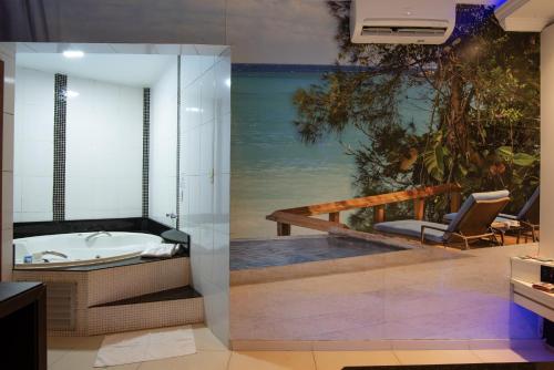 uma casa de banho com banheira e vista para o oceano em Motel Fantasy 2 (Adult Only) em Contagem