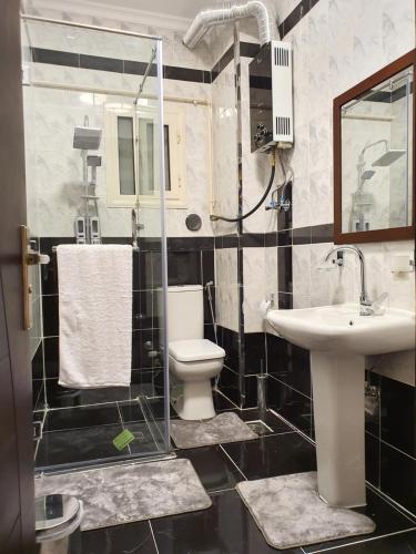 a bathroom with a toilet and a sink at YOUVALA Serviced Apartment 2nd District in 6th Of October