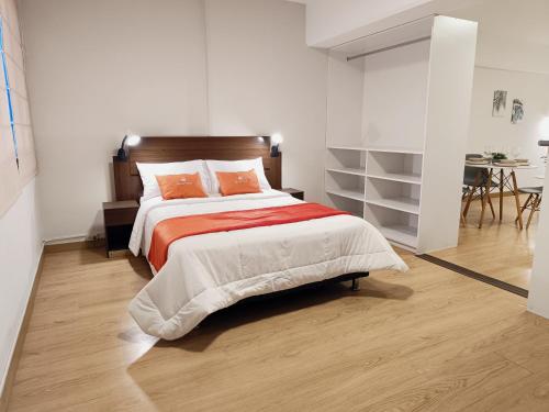 a bedroom with a bed with orange sheets and a table at Runawasi Loft - Raywa 1 BDR, Centric and confortable. in Lima