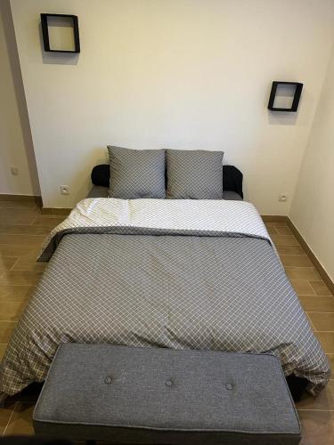 een groot bed in een kamer met 2 kussens bij Carol California in Chevigny-Saint-Sauveur