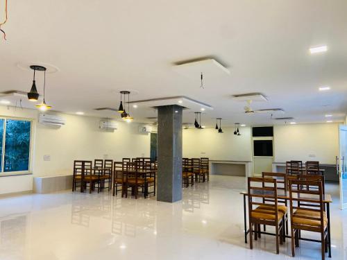 a dining room with chairs and tables in a room at New Corbett Hotel and Resort in Belparāo