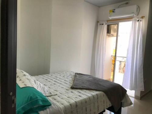 a bedroom with a bed and a window with a window at Hermoso apto en Barrancabermeja in Barrancabermeja