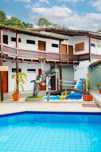 a house with a swimming pool in front of a building at Hotel Casa Blanca Porto Seguro in Porto Seguro