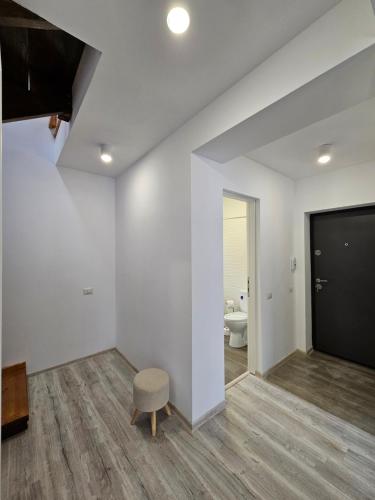 ein Wohnzimmer mit weißen Wänden und einem Stuhl in der Unterkunft Magic Mountain View Busteni in Buşteni