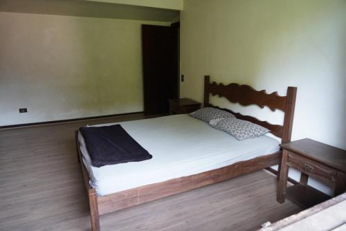 a bedroom with a wooden bed and a table at Casa em Condomínio Estrada de São Roque Estrada do Vinho in São Roque