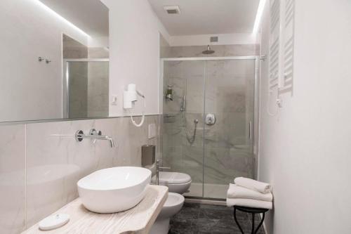 Hotel L'Antico Pozzo في سان جيمنيانو: حمام مع حوض ومرحاض ودش