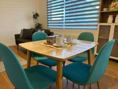 納塔列斯港的住宿－Tú Casa en Puerto Natales，一张带蓝色椅子的木桌和一间餐厅