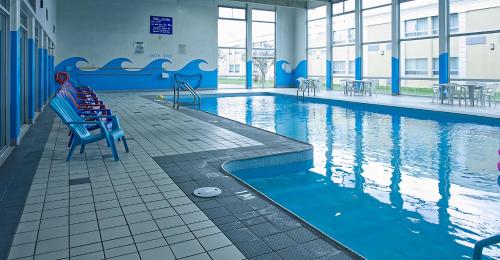 una piscina con un banco azul en un edificio en Ramada by Wyndham London, en London