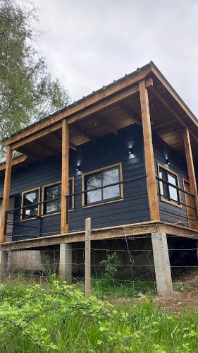 Casa azul con porche y ventanas en Wincarayen Lodge & Cabañas, en Panguipulli