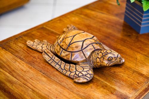 a figurine of a turtle on a wooden table at Hotel Casa Blanca Porto Seguro in Porto Seguro