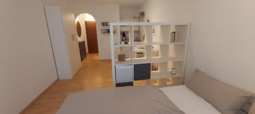 維爾茨堡的住宿－nette 1 Zimmerwohnung in Würzburg，一间设有床铺和白色架子的房间