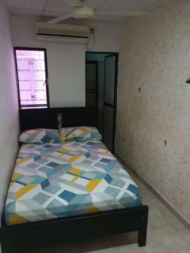 Aparta Hotel Bethesda في أغواتشيكا: غرفة نوم مع سرير مع لحاف ملون