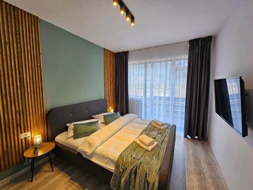 a bedroom with a bed and a large window at Magic Mountain View Busteni in Buşteni