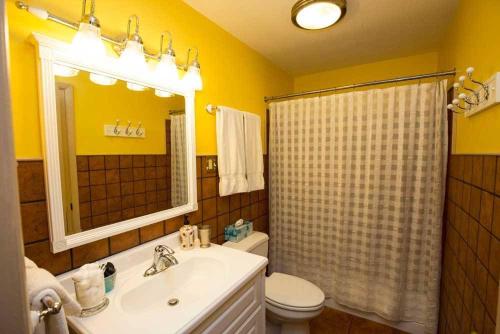 a bathroom with a sink and a toilet and a mirror at Dodici Night Suites in Washington