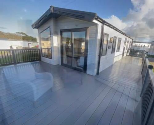 a house with a large deck with a building at 2-6 guests Holiday Chalet in Durdle Door in West Lulworth