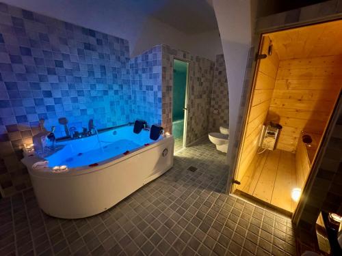 een badkamer met een groot bad en een toilet bij Lamapulia in Torre a Mare