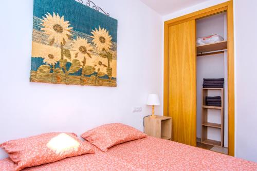 Un dormitorio con una cama con un cuadro en la pared. en Beach House Millares, en Carboneras