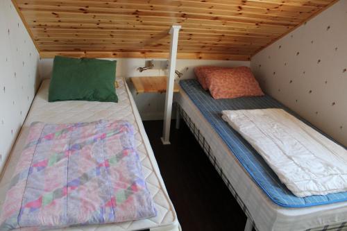 - 2 lits dans une chambre dotée de plafonds en bois dans l'établissement Gästvåning i Hajstorp, à Töreboda