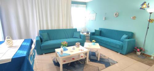 ein Wohnzimmer mit 2 blauen Sofas und einem Tisch in der Unterkunft La casa del sole "tra l'Etna e il mare" in Acireale