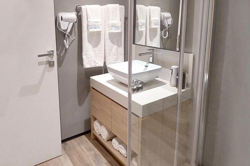 La salle de bains est pourvue d'un lavabo et d'un miroir. dans l'établissement Emerald Apt at Maho Beach, à Maho Reef