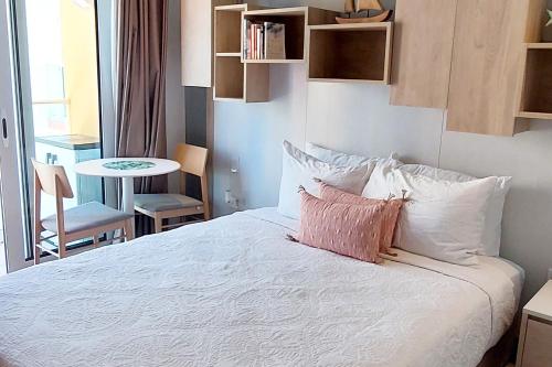 1 dormitorio con 1 cama con sábanas y almohadas blancas en Emerald Apt at Maho Beach, en Maho Reef