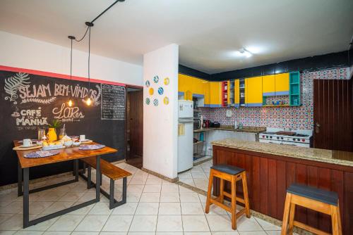 ブルマジーニョにあるHostel LAResのキッチン(黄色のキャビネット、テーブル、椅子付)