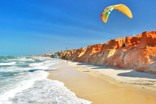 una persona está volando una cometa en la playa en Premium Flats - Praia Mansa, en Fortaleza