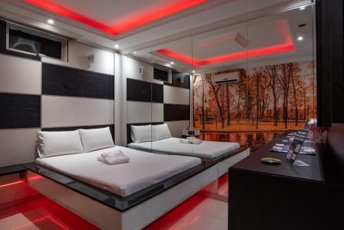 two beds in a room with red lighting at Motel Fantasy 2 (Adult Only) in Contagem