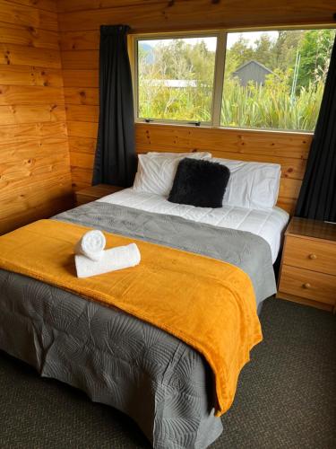 a bedroom with a large bed with a window at Franz Josef TOP 10 Holiday Park in Franz Josef