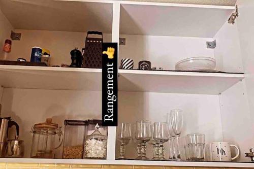 a shelf with glasses on it in a kitchen at Appartement PROUDHON in Tarascon