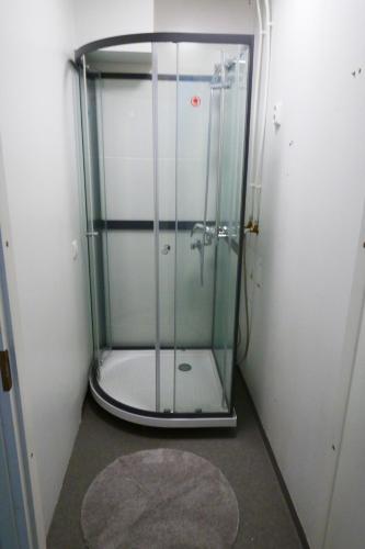 a shower with a glass door in a room at Lähellä keskustaa in Kitee