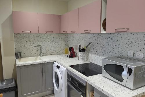 La cuisine est équipée d'un four micro-ondes et d'un évier. dans l'établissement Apartment with garden - sea view, à Palavas-les-Flots