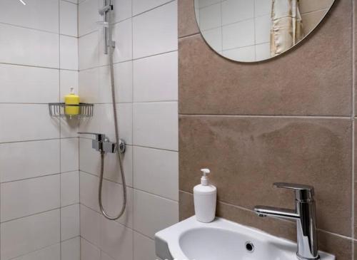 een badkamer met een douche, een wastafel en een spiegel bij Good apart 668 in Tbilisi City