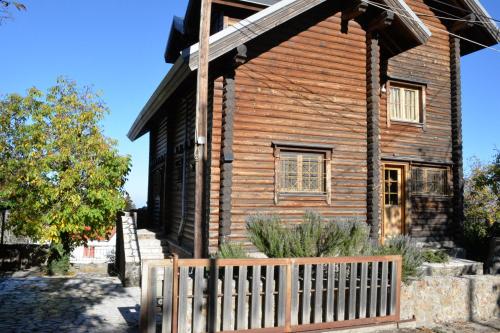 an old wooden house with a wooden fence at Oreias Chalet in Ano Trikala