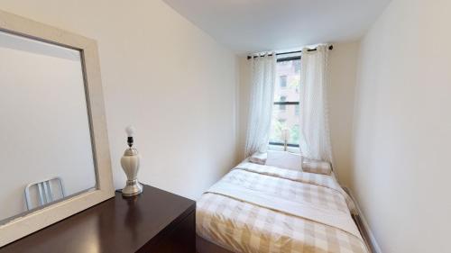 um quarto com uma cama ao lado de uma janela em Cozy place in midtown NYC em Nova York