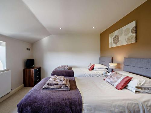 a bedroom with two beds and a tv at 2 Bed in Mellor FINCH in Blackburn