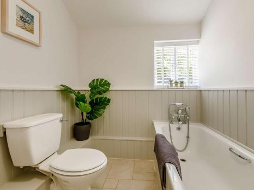 a bathroom with a toilet and a bath tub at 3 Bed in Budleigh Salterton 88004 in Otterton