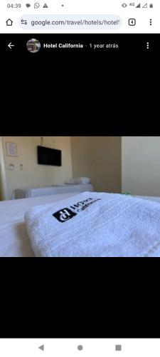uma fotografia de um quarto com uma cama branca em Hotel California em Goiânia