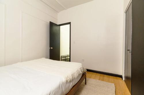 1 dormitorio con cama blanca y espejo en Apartment 190: Upper East Side, en Nueva York