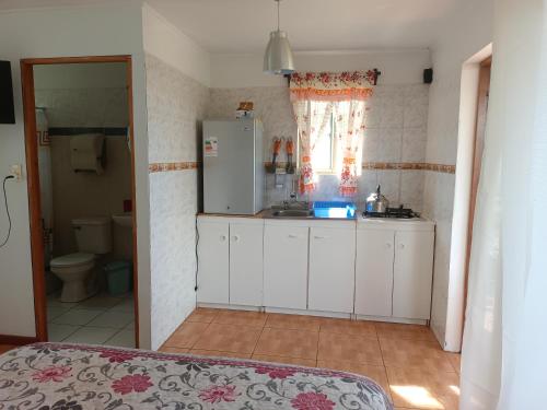 a kitchen with a white refrigerator and a sink at cabañas Te Pito Kura in Hanga Roa