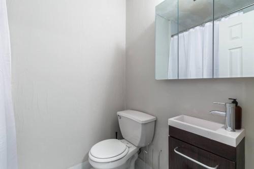 La salle de bains est pourvue de toilettes, d'un lavabo et d'un miroir. dans l'établissement Apartment 332: Hells Kitchen, à New York