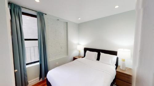 a bedroom with a white bed and a window at Apartment 494: East Village in New York