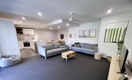 a living room with two couches and a kitchen at Unit 2 - Manly Boutique Apartments in Brisbane